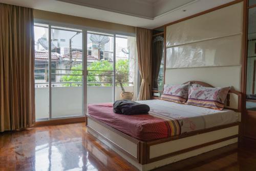 a bedroom with a bed and a large window at Modern Home in Sukhumvit in Bangkok