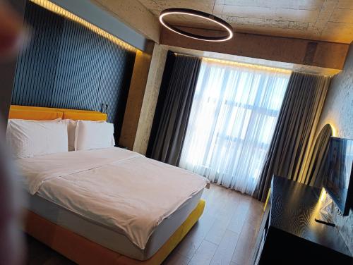 a hotel room with a bed and a window at Toka Hotel Restaurant in Pogradec