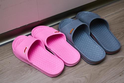 four pairs of flip flops sitting on the floor at 香港智能居家旅館雙人入住首選 in Hong Kong