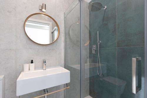 a bathroom with a sink and a mirror and a shower at Associazione Garage24 Aps Ets in Portoferraio