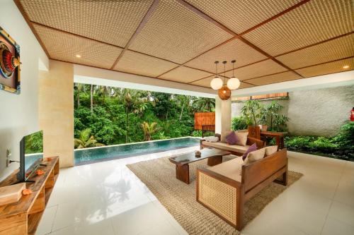 a living room with a pool and a couch and a table at Dedary Resort & Spa Ubud by Ini Vie Hospitality in Ubud