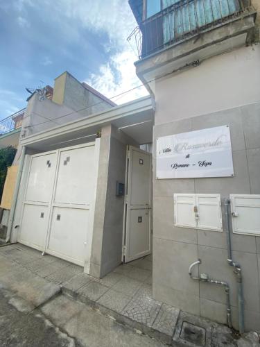 a building with two garage doors and a sign on it at Luxury Rosaverde in Frattamaggiore