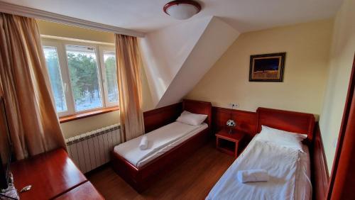 mały pokój z 2 łóżkami i oknem w obiekcie La Dora Mountain Resort w mieście Divčibare