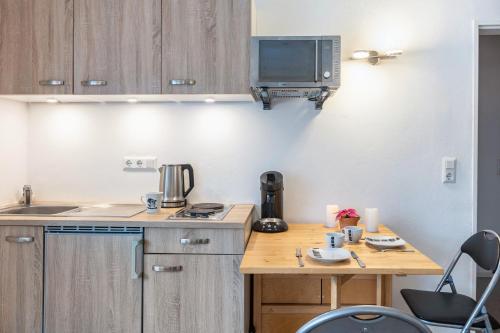 a small kitchen with a table and a microwave at Struthhof in Finsternthal