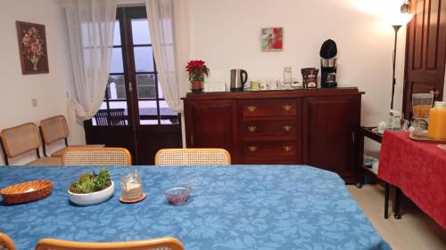 einen Esstisch mit einem blauen Tischtuch und Stühlen in der Unterkunft Alto da Praia Villa in Colares