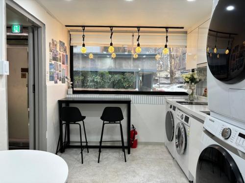 a kitchen with a table and two stools at Sillim Leo's House in Seoul