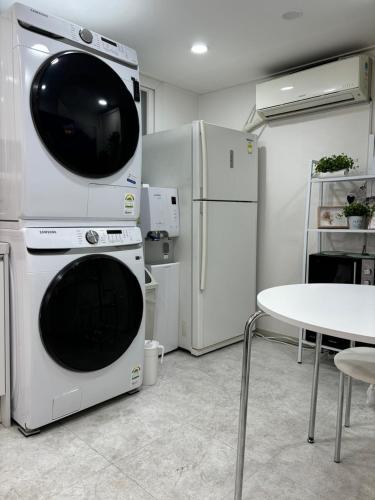 a kitchen with two white appliances and a table at Sillim Leo's House in Seoul