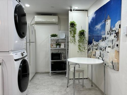 a laundry room with a table and a washer at Sillim Leo's House in Seoul