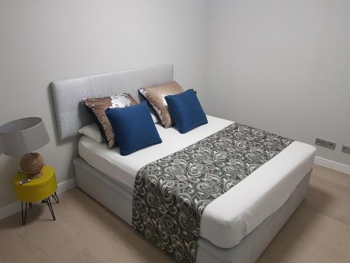 ein Schlafzimmer mit einem Bett mit blauen Kissen darauf in der Unterkunft Luxury Home in Las Palmas de Gran Canaria