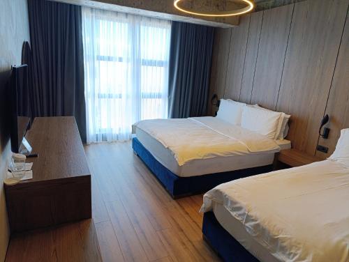a hotel room with two beds and a table at Toka Hotel Restaurant in Pogradec
