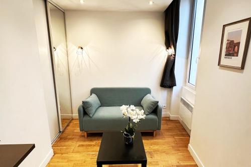 un salon avec un canapé vert et une table dans l'établissement Coquet petit Studio Hyper centre Lumineux avec Terrasse, à Marseille