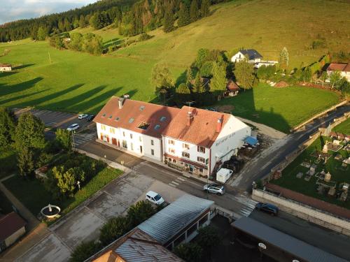 - une vue aérienne sur un grand bâtiment blanc avec un parking dans l'établissement L'Orée Du Lac, à Grande-Rivière