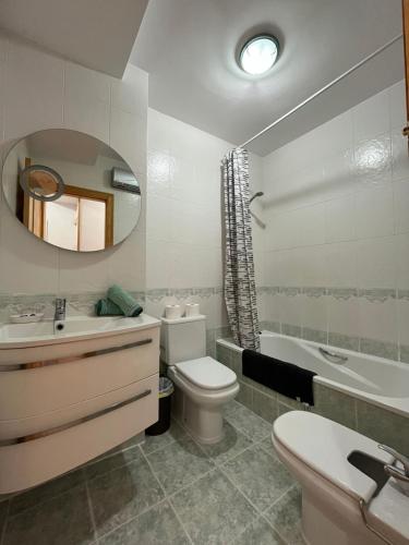 a bathroom with a sink toilet and a mirror at El Balcón de Peñiscola in Peñíscola
