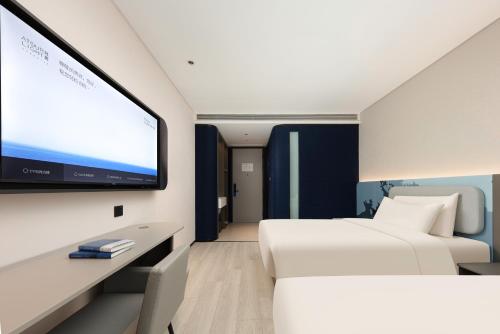 a hotel room with two beds and a flat screen tv at Atour Hotel Wuhan Hubei University Xudong in Wuhan