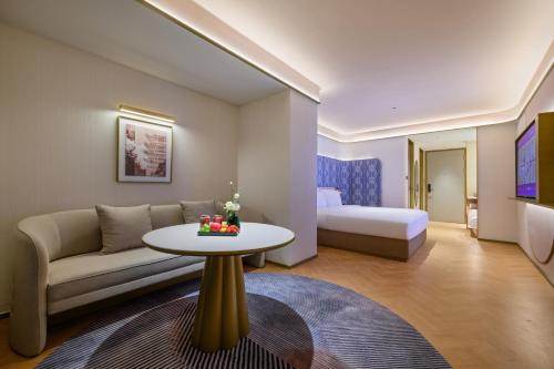 武漢市にあるManxin Hotel Wuhan Hankou Fanhai CBD Xinhua Roadのソファとテーブルのあるリビングルーム