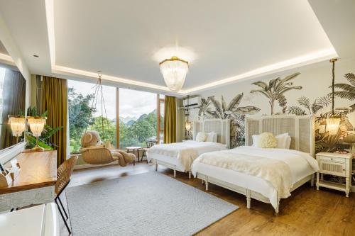 桂林市にあるGuilin Red Roof Garden Resort --Within 8000 square meter lush garden- Fluent English-Southeast Asian style decoration-Quiet and delightfulのベッドが2つと大きな窓がある寝室