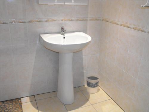 La salle de bains est pourvue d'un lavabo blanc. dans l'établissement Chambres chez l'habitant Coco2, à Boulazac