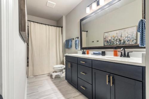 a bathroom with a sink and a toilet and a mirror at Contractor Friendly 3 Kings Pet Welcome in Lake Charles