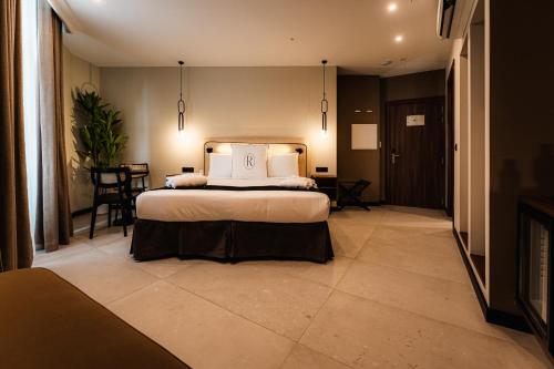 a bedroom with a bed and a table and chairs at Royale Sainte Hélène Boutique Hotel in Birkirkara