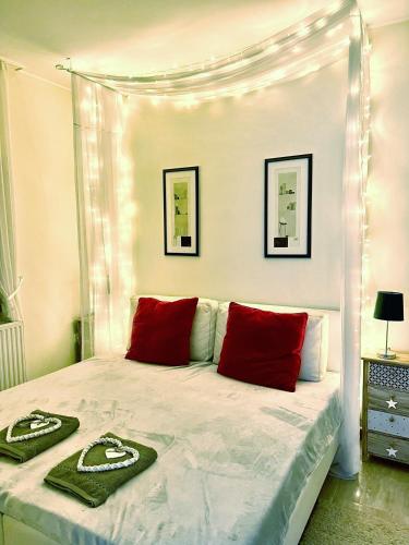 a bedroom with a canopy bed with red pillows at Villa Relax Apartman in Gárdony