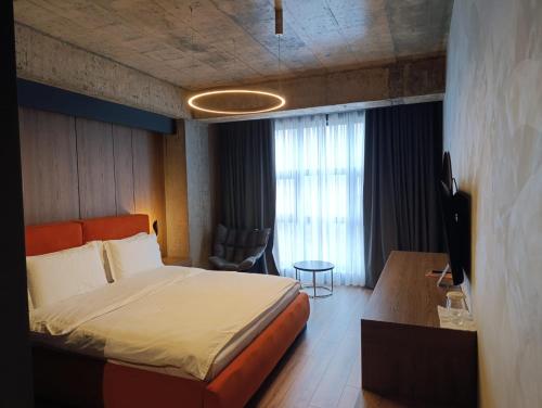 a bedroom with a bed and a desk with a television at Toka Hotel Restaurant in Pogradec