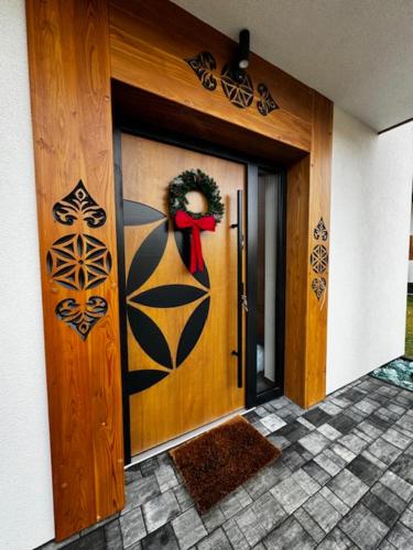 a front door of a house with a wreath on it at Porębiańska Osada Resort & Spa in Szlembark