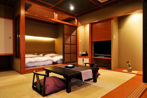 a bedroom with a bed and a table in a room at Rakuyu in Fujikawaguchiko