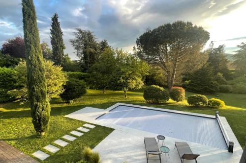 une piscine au milieu d'un jardin dans l'établissement Villa Birdie - Belle maison avec piscine, à Cailloux-sur-Fontaines