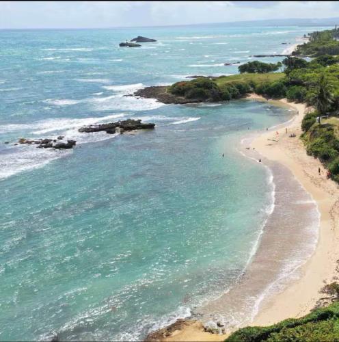 an aerial view of a beach with people in the water at Residencial Nany in San Felipe de Puerto Plata