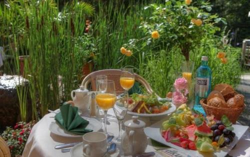 a table with glasses of orange juice and a plate of food at Seehotel Ecktannen in Waren