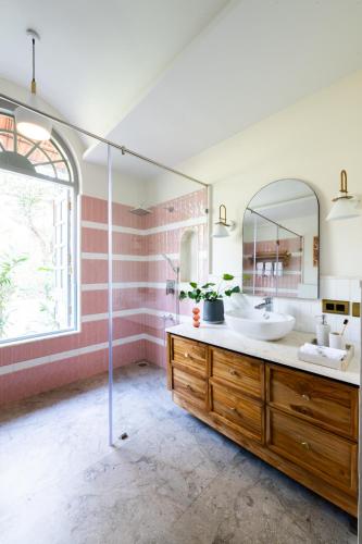 a bathroom with two sinks and a mirror at LohonoStays Regato Villa E in Siolim