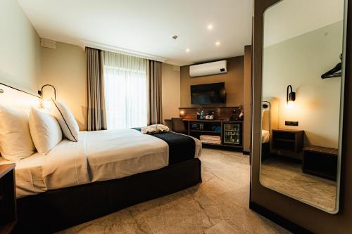 a hotel room with a bed and a mirror at Royale Sainte Hélène Boutique Hotel in Birkirkara