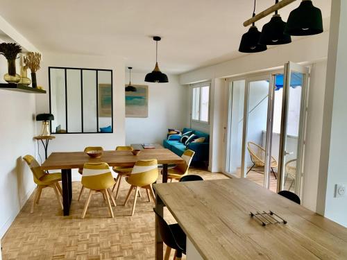 un salon avec une table et des chaises en bois dans l'établissement 10 mns à pieds de l'hyper centre, vue sur le canal du midi, à Toulouse