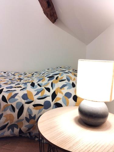 a bedroom with a bed and a table with a lamp at Maison Indépendante in Soissons-sur-Nacey