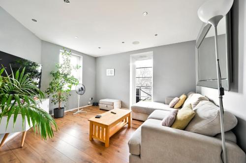 a living room with a couch and a table at Cosy 1-Bed E15, sleeps 4, 1 min from tube Station Near O2 Arena in London