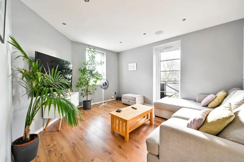 a living room with a couch and a table at Cosy 1-Bed E15, sleeps 4, 1 min from tube Station Near O2 Arena in London