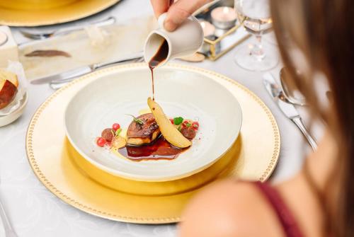 a person holding a spoon over a plate of food at Hotel Elizabeth in Trenčín