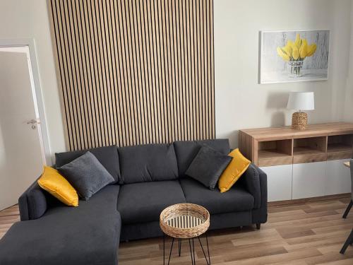 a living room with a black couch with yellow pillows at Aparthotel Praha in Prague