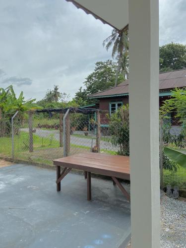 a wooden bench sitting in front of a fence at Delima Cottage, a cozy studio in Melaka, Masjid Tanah in Masjid Tanah