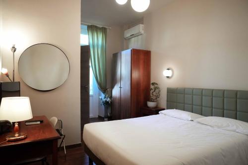 a bedroom with a bed and a mirror and a table at Hotel Universo in Turin