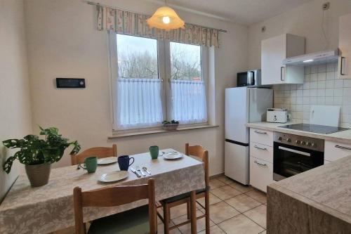 a kitchen with a table with chairs and a refrigerator at Apartment Kleine Auszeit in Wiendorf