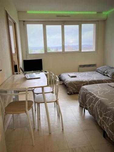 - une chambre avec un bureau, un ordinateur portable et un lit dans l'établissement Appartement double 16 à LIMOGES, à Limoges