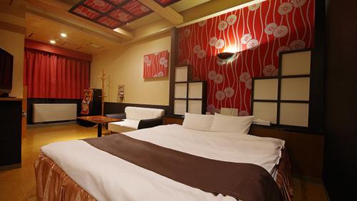 a bedroom with a large bed in a room at Hotel Dolphin in Ishinomaki