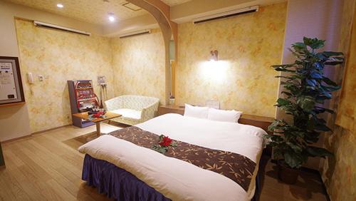 a bedroom with a large bed in a room at Hotel Dolphin in Ishinomaki