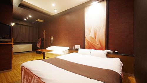 a bedroom with a large bed in a room at Hotel Dolphin in Ishinomaki