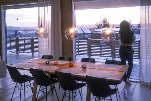 a woman standing in a room with a table and chairs at Tupasvilla in Saariselka