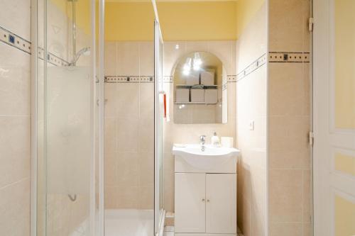 une salle de bain avec un lavabo et une douche dans l'établissement Rez de jardin à 500 m de la plage, à Cagnes-sur-Mer