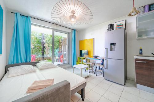 Il comprend une chambre avec un lit et une cuisine équipée d'un réfrigérateur. dans l'établissement Rez de jardin à 500 m de la plage, à Cagnes-sur-Mer