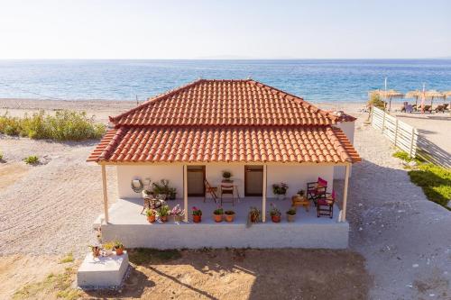 a small house on the beach next to the ocean at Svala SeaView beach house in Samos