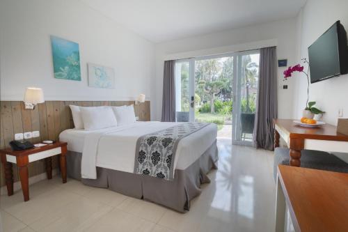 a bedroom with a large bed and a sliding glass door at Royal Regantris Villa Karang in Gili Air